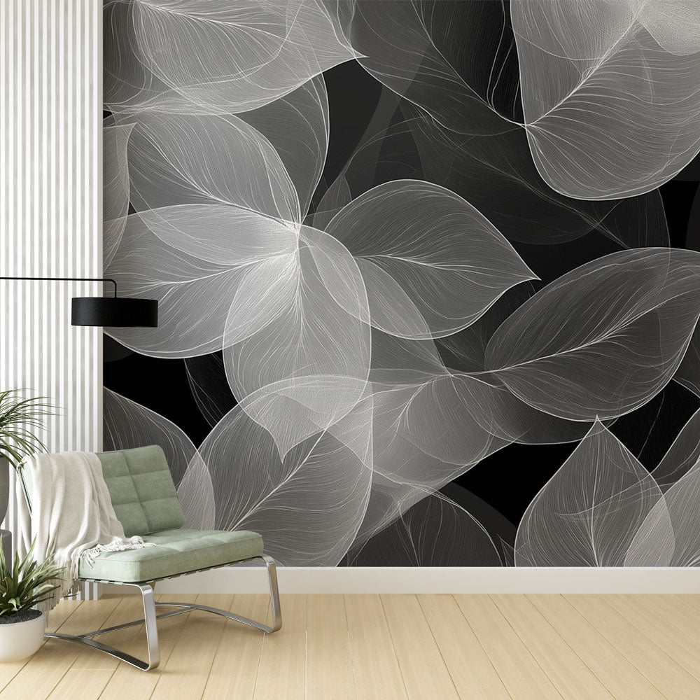 Modern black and white leaf wallpaper creating depth in a minimalist living room with natural light highlighting the translucent design
