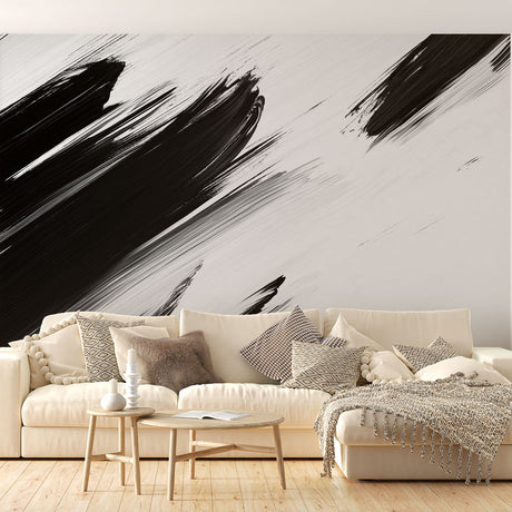 Black and white abstract brushstroke mural wallpaper creating drama in a modern living room with minimalist furniture