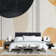 Modern geometric wallpaper with black and gold circles creating depth in a minimalist living room setting