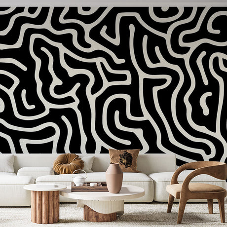Modern black and white maze pattern wallpaper creating a stunning feature wall in a minimalist living room with natural lighting