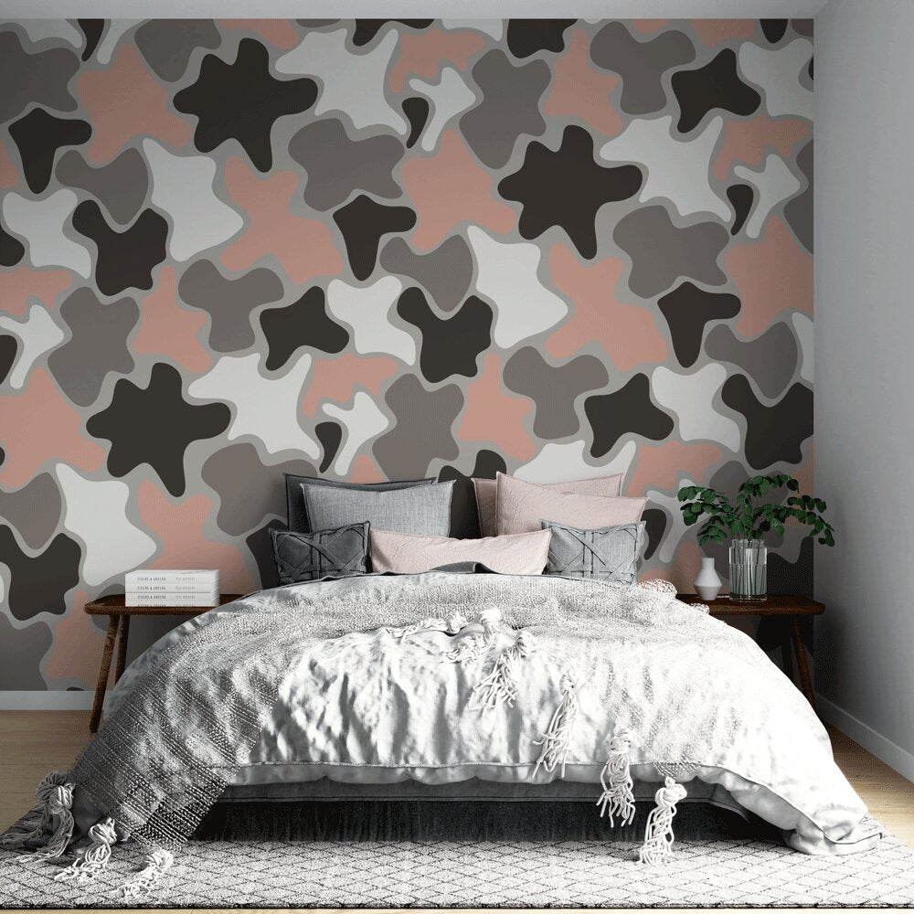 Modern abstract camo wallpaper in soft pastels shown in a bright living room setting with minimal furniture