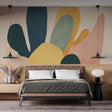 Abstract organic shapes wallpaper in green and gold creating a modern statement wall in a bright living room setting
