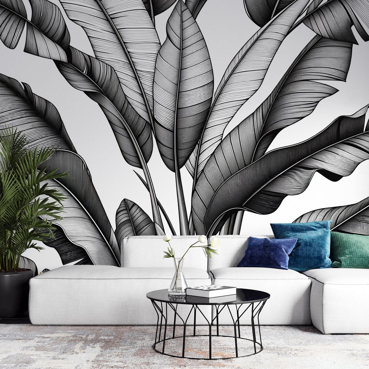 Black and white banana leaf wallpaper in modern living room showing dramatic scale and contrast