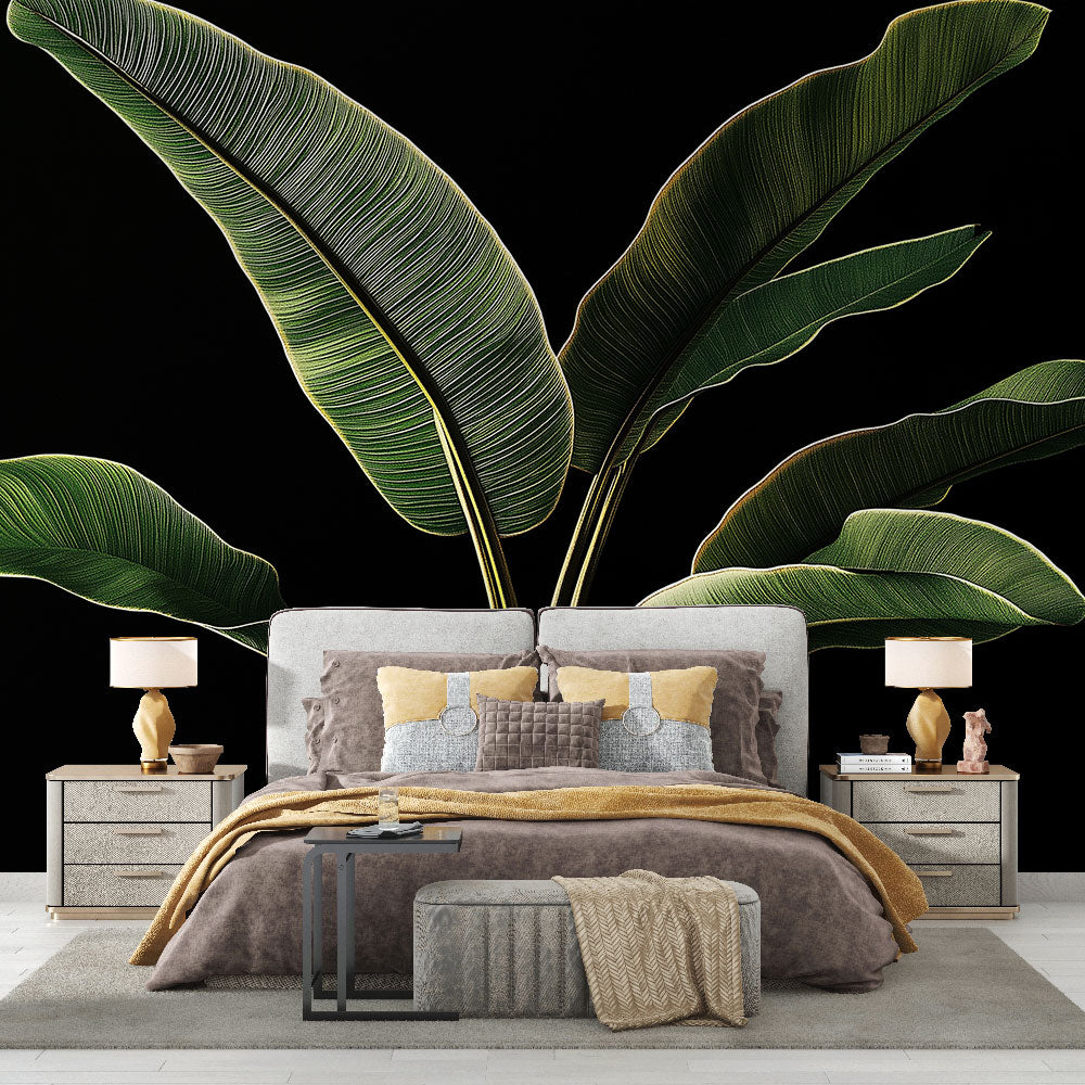 Tropical banana leaf wallpaper creating dramatic impact in a modern living room with black accent wall and gold accessories