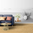 Black and white beach scene wallpaper creating a calm atmosphere in a modern living room with minimal furniture