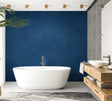 Navy blue textured wallpaper in modern living room with grey sofa and natural light