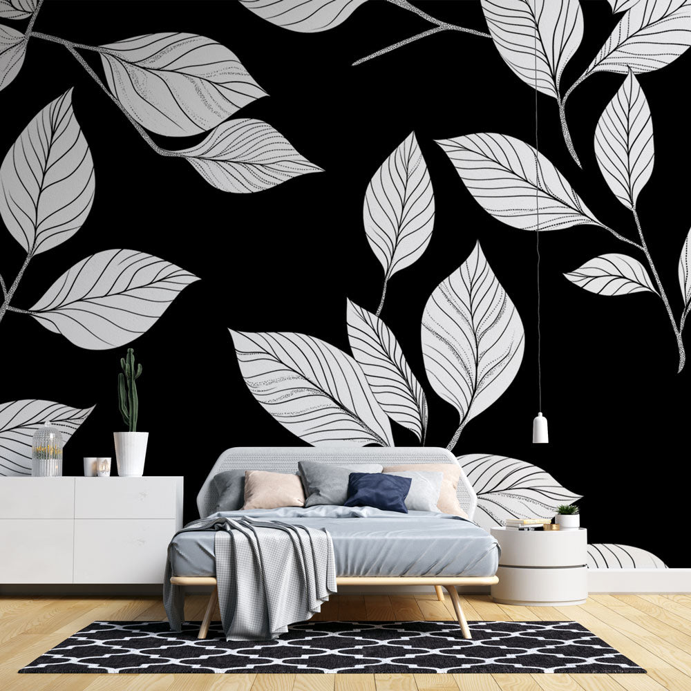Black and white botanical wallpaper creating dramatic impact in modern living room with gray sofa and natural light