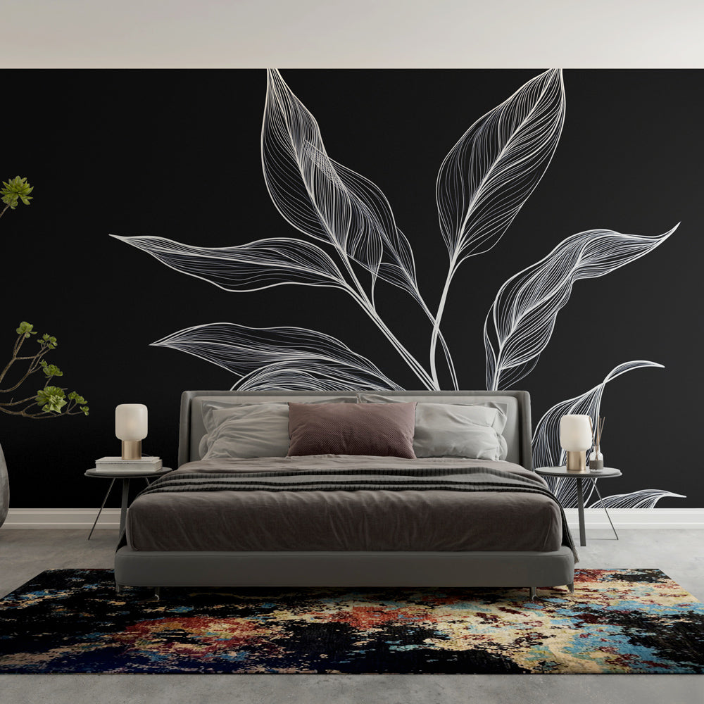 Botanical black and white leaf wallpaper creating dramatic contrast in a modern living room with minimalist furniture