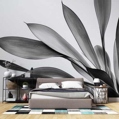 Black and white botanical leaf wallpaper creating drama in a modern living room with clean furniture and natural light