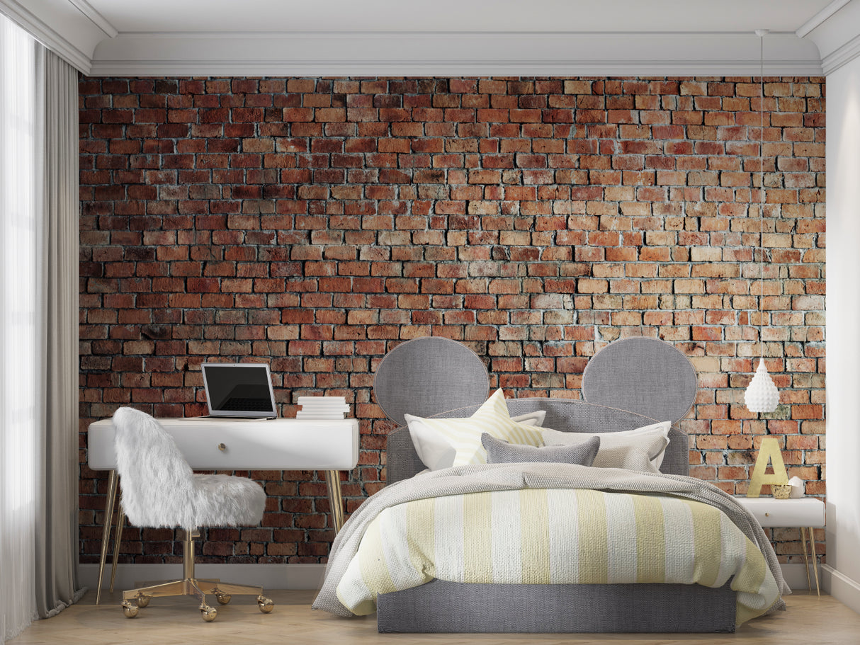 Brick wall mural creating an industrial vibe in a modern living room with grey sofa and metal accents