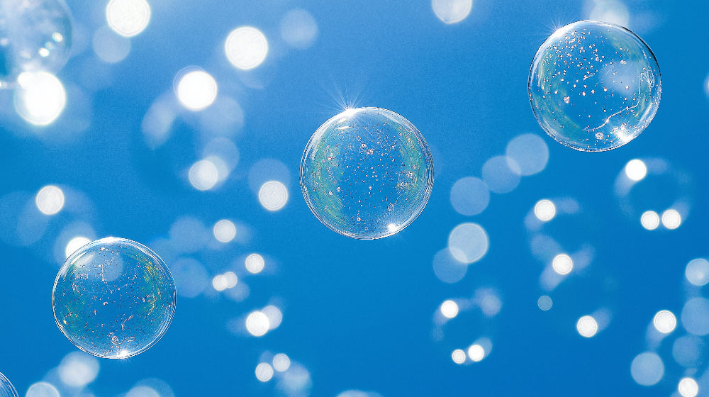 Bubble wallpaper mural creating a dreamy atmosphere in a modern living room with floating spheres against blue sky background