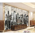 Black and white city skyline wallpaper creating dramatic impact in modern living room with grey sofa and minimal decor