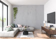 Modern grey concrete effect wallpaper in a minimalist living room with natural lighting