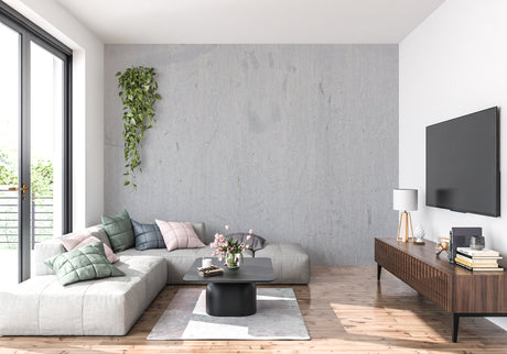 Modern grey concrete effect wallpaper in a minimalist living room with natural lighting