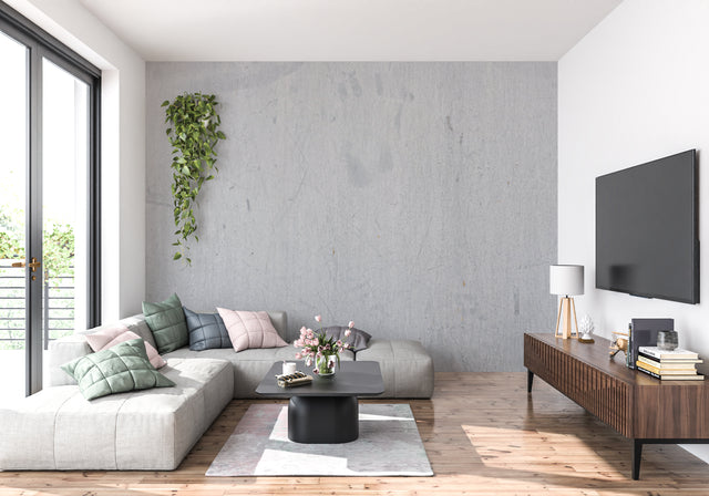 Modern grey concrete effect wallpaper in a minimalist living room with natural lighting