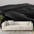 Black and white desert dunes wallpaper creating a dramatic focal point in a modern minimalist living room with clean lines