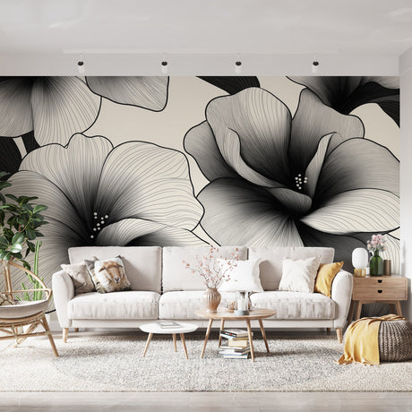 Black and white hibiscus floral wallpaper creating a dramatic focal point in a modern living room with minimalist furniture
