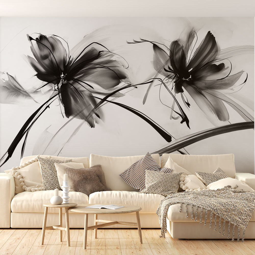 Black and white floral wallpaper mural creating an elegant statement wall in a modern living room with minimalist furniture