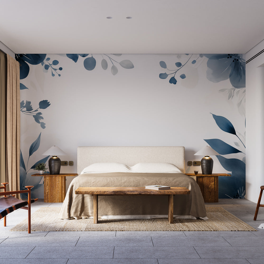 Blue floral wallpaper mural displayed in a bright modern living room, showing watercolor botanical design in navy and slate blue tones