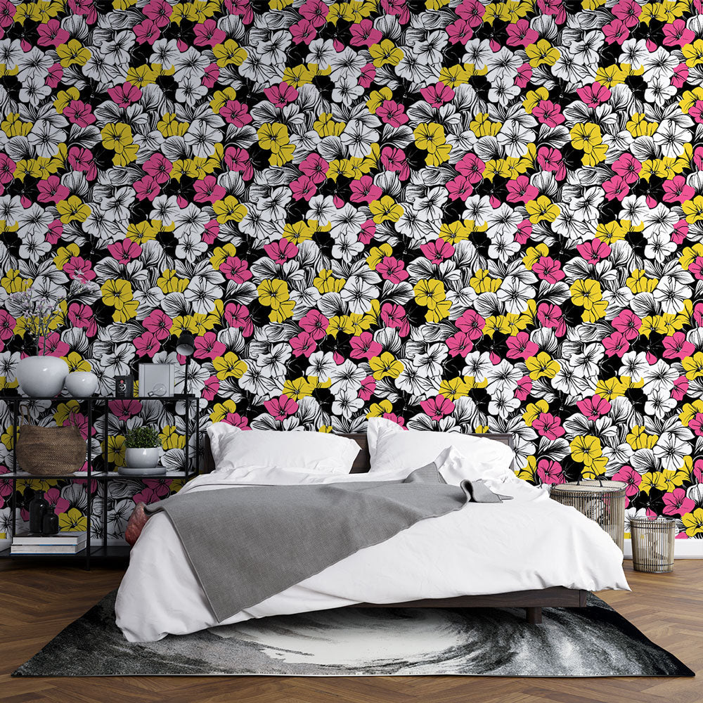 Modern floral wallpaper with pink and yellow blooms on black background styled in a bright living room setting