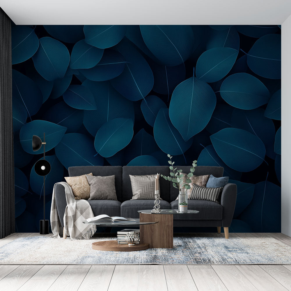 Blue leaf wallpaper mural creating a calm atmosphere in a modern living room with grey sofa and natural light