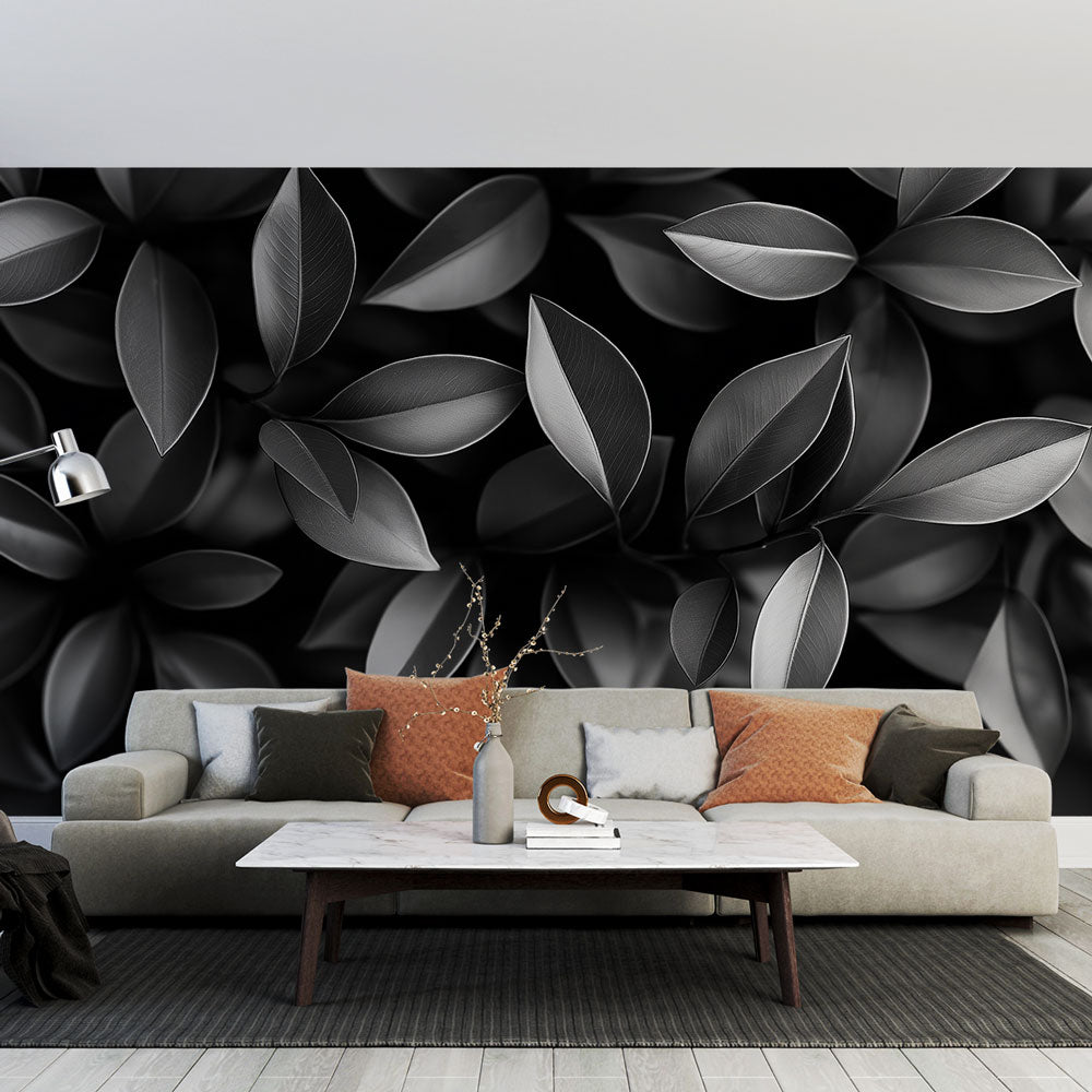 Black and white leaf wallpaper creating depth in a modern living room with grey sofa and natural light