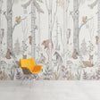 Forest animals wallpaper creating a cozy atmosphere in a bright nursery with white furniture and pink accents