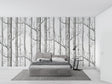 Black and white forest wallpaper creating depth in modern living room with minimal furniture