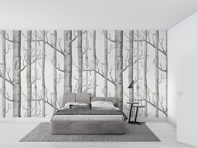 Black and white forest wallpaper creating depth in modern living room with minimal furniture