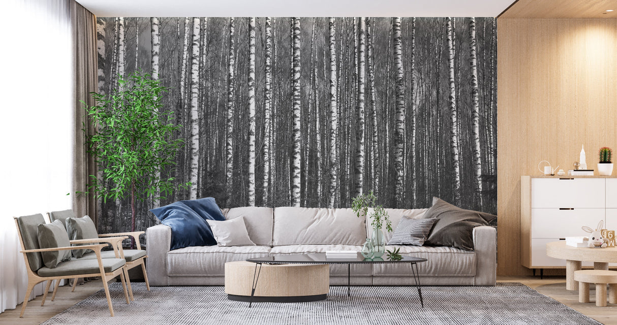 Black and white forest wallpaper creating depth in a modern living room with minimal furniture