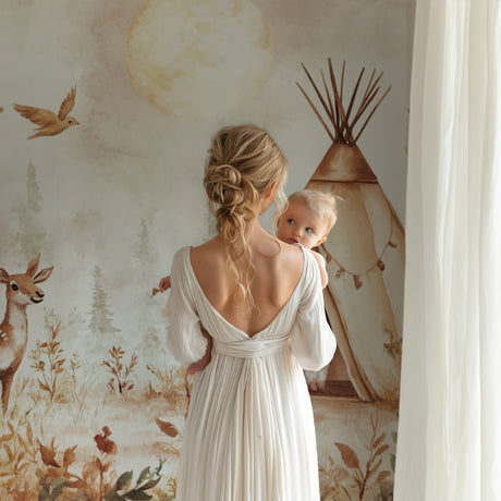 Woodland deer wallpaper mural in a cozy nursery with natural wood furniture and soft lighting