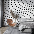 Black and white geometric wallpaper creating drama in a modern living room setting