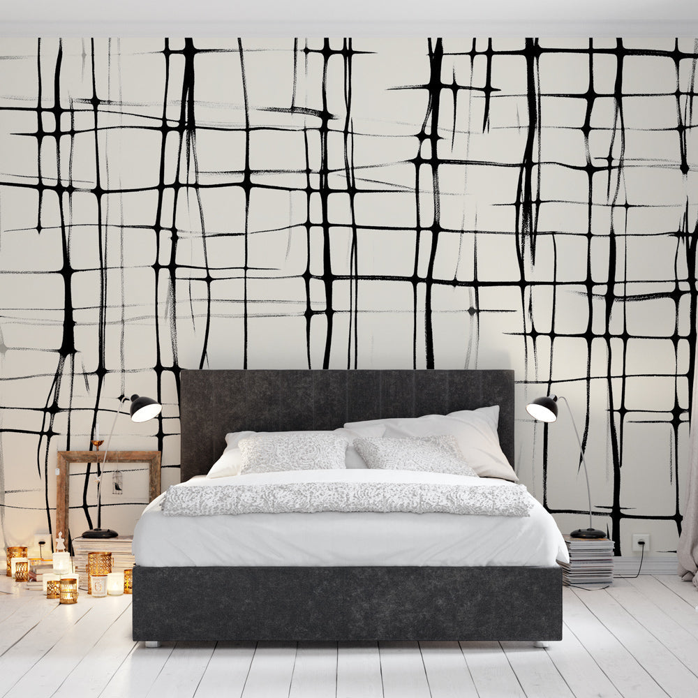 Modern black grid geometric wallpaper creating a striking focal point in a minimalist living room with natural light