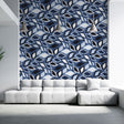 Modern geometric leaf wallpaper in blue tones creating a striking accent wall in a minimalist living room setting