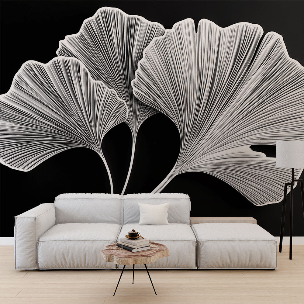 Black and white ginkgo leaf wallpaper creating dramatic contrast in a modern living room with minimalist furniture