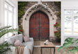 Gothic door mural wallpaper in a grand entrance hall, showing stone arch and red wooden door