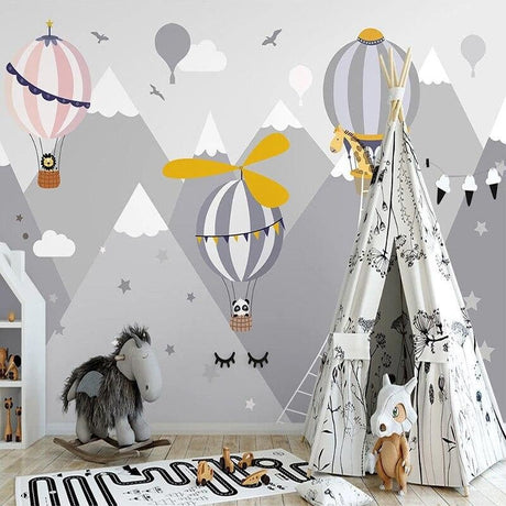 Hot air balloon nursery wallpaper creating a dreamy atmosphere in a soft pink kids bedroom with mountain views