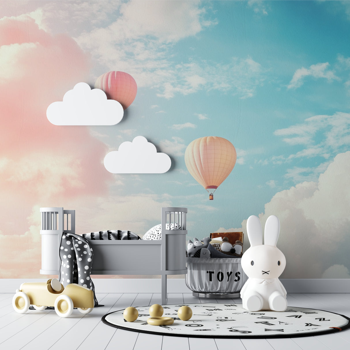Hot air balloon wallpaper in a bright nursery with white furniture and pink accents