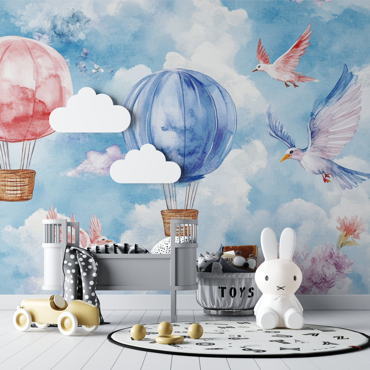 Pink and blue balloon wallpaper making a statement in a minimalist baby room