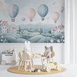 Hot air balloon nursery wallpaper creating a soft, dreamy atmosphere in a baby girl's room with pink and white furniture