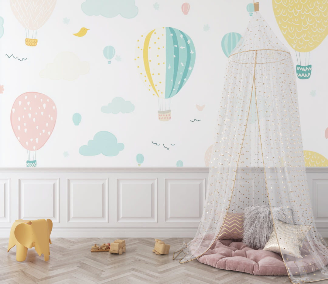 Hot air balloon nursery wallpaper in a bright, modern nursery with white furniture