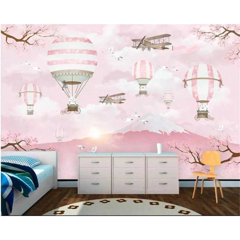 Hot air balloon wallpaper creating a magical atmosphere in a bright nursery with pink accents and white furniture