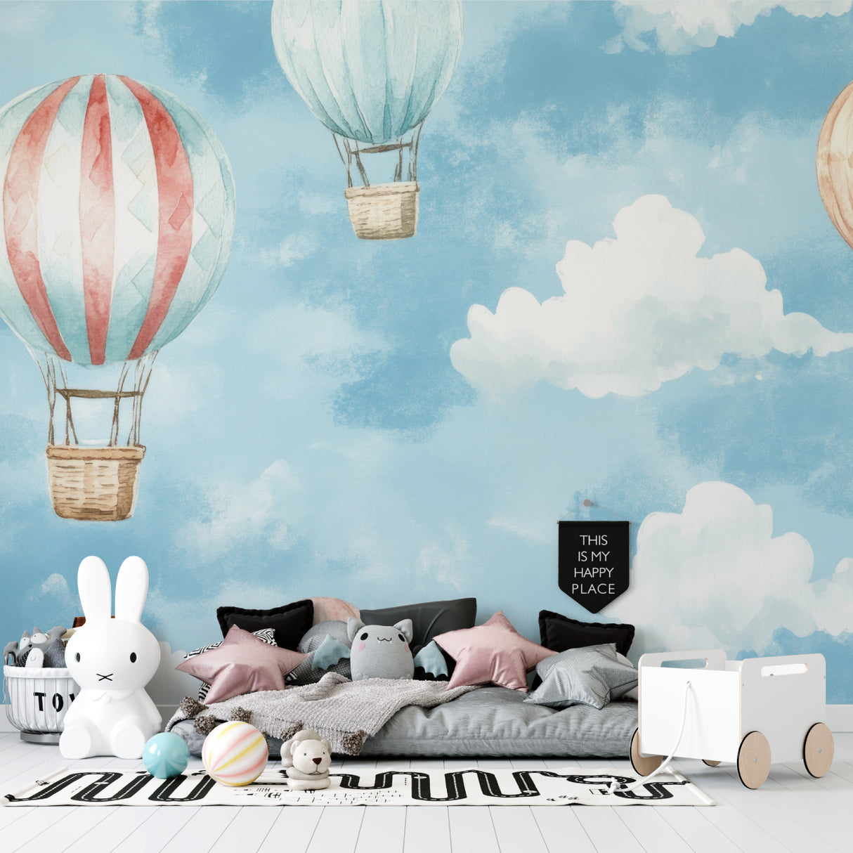 Hot air balloon wallpaper in a bright nursery with white furniture, showing soft watercolor design