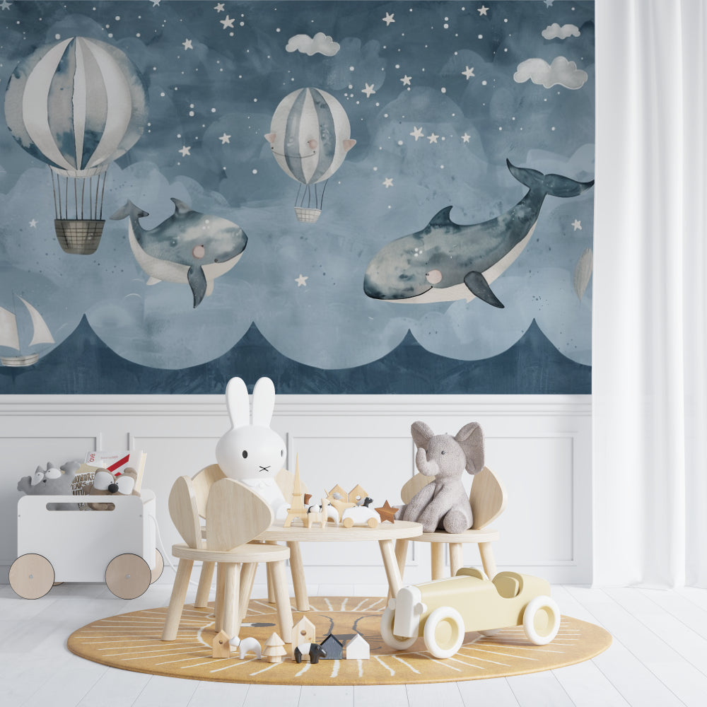 Whale and balloon wallpaper mural in a modern nursery with white furniture and soft lighting