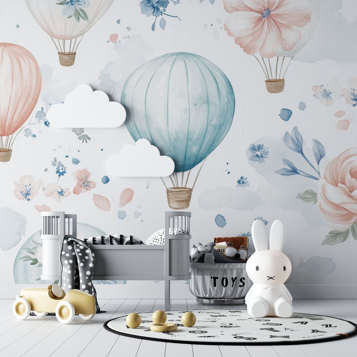 Hot air balloon nursery wallpaper in a bright, airy baby room with white furniture and soft textiles