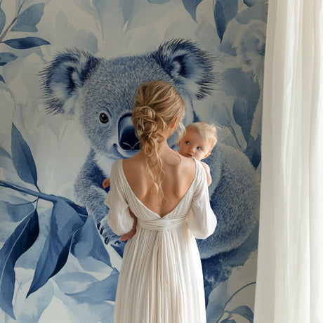 Koala wallpaper mural in a modern nursery with white furniture and soft blue accents