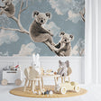 Koala wallpaper mural in a bright nursery with white furniture, showing gentle morning light