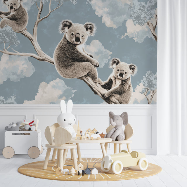 Koala wallpaper mural in a bright nursery with white furniture, showing gentle morning light