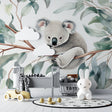 Koala wallpaper mural in a bright nursery with white furniture, showing the full wall design