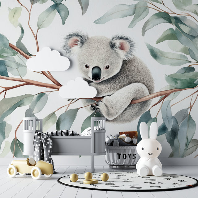 Koala wallpaper mural in a bright nursery with white furniture, showing the full wall design